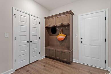 Mudroom featuring light wood finished floors and baseboards