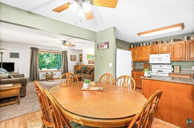 Dining space with ceiling fan and light colored ca