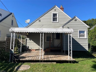 Back of house featuring a lawn and a deck