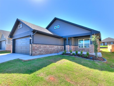 View of front of property with an attached garage, brick siding, driveway, a front yard, and covered porch