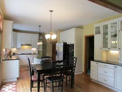 The updated Kitchen is enhanced with hardwood flooring,  granite counters, tiled backsplash and under cabinet lighting.