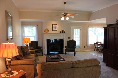 The living room 16x19 with a fireplace, new carpet, crown molding and recessed lighting.