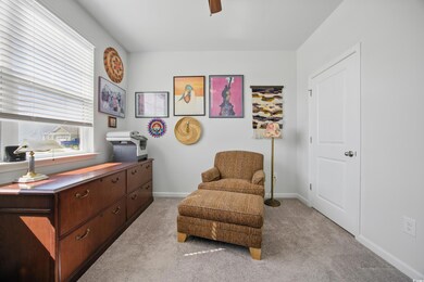 Living area with light colored carpet, a ceiling fan, and baseboards