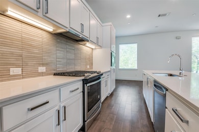 Kitchen with tasteful backsplash, visible vents, a