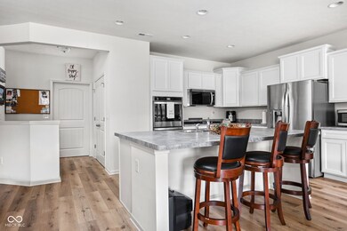 Kitchen boasts gas cooktop, double ovens, micro-hood (2025), and expansive island seating-perfect for entertaining.
