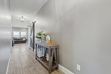 Hall with a barn door and light hardwood / wood-st