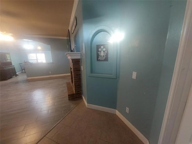 Corridor with ornamental molding, baseboards, and wood finished floors