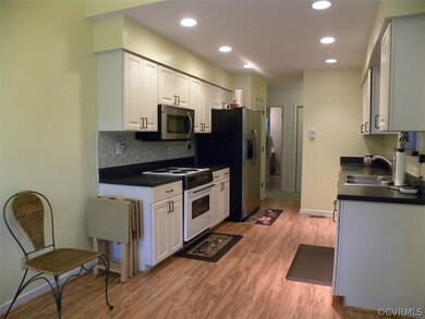 Kitchen with hardwood, backsplash, electric cooking, microwave, dishwasher, disposal, stainless steel side by side refrigerator, recessed lights, pantry