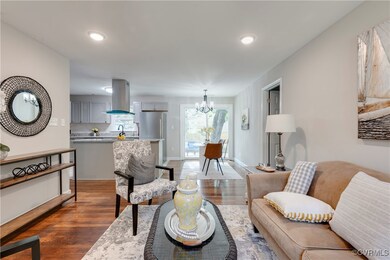 Living room featuring dark hardwood / wood-style flooring and a notable chandelier