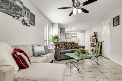 Tiled living room with ceiling fan with notable ch
