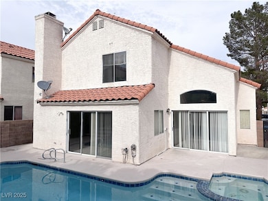 Rear view of property with a tile roof, stucco sid