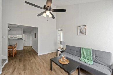 Living room featuring ceiling fan, a high ceiling,