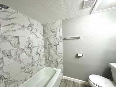 The restroom features a shower/tub combo and a clean, functional layout.
