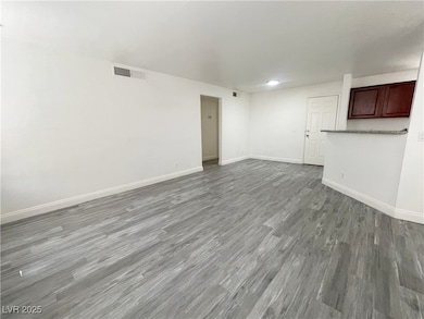 Spare room featuring wood finished floors and baseboards