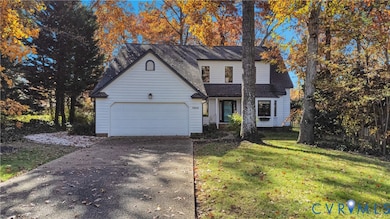 View of front of home featuring driveway, roof with shingles, a front yard, and a garage