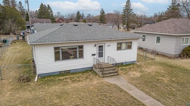 View of front of property featuring roof with shingles, a front lawn, and fence