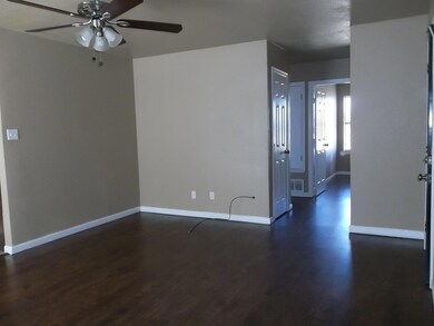 Spare room with dark wood-type flooring and ceiling fan