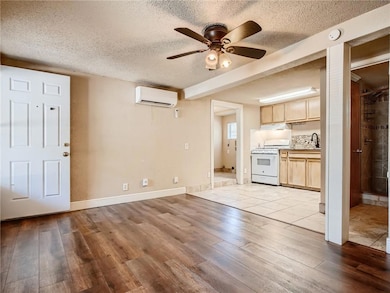 Kitchen with white gas stove, a ceiling fan, a te