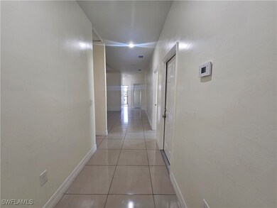 Corridor with light tile patterned floors and base