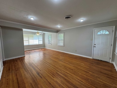 Large room featuring crown molding, hardwood flooring, lots of natural light. It's a blank canvas waiting for the perfect new owner.