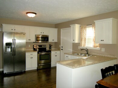 The kitchen features desirable white cabinets. Range, microwave and dishwasher all remain. 