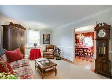 The living room features crown dentil moulding and wainscoting.