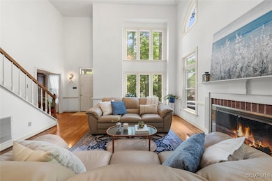 Living area featuring a brick fireplace, stairs, w