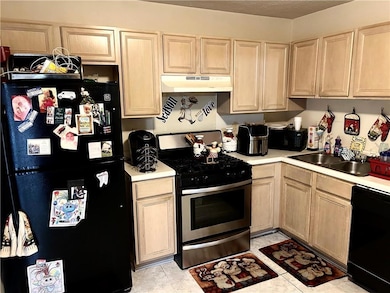 Kitchen with sink, black appliances, light brown c