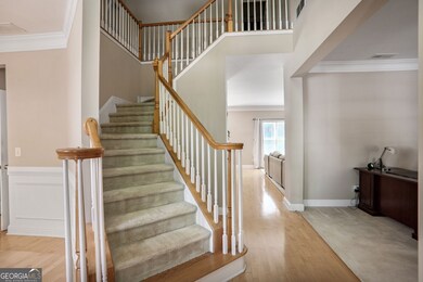 Elegant 2-story foyer featuring a grand curved staircase, soaring ceilings, and abundant natural light perfect for making a stunning first impression