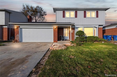 Traditional-style home with a front yard, brick siding, driveway, an attached garage, and a chimney