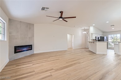 Unfurnished living room with vaulted ceiling, a ti