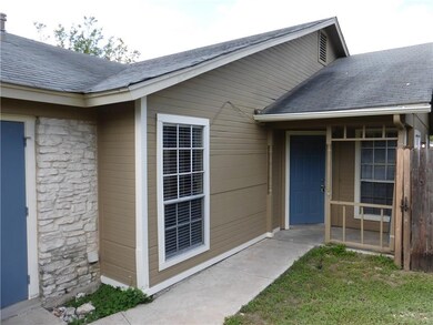 Property entrance with a shingled roof and stone 