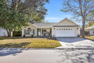 Single story home featuring a front yard and a gar