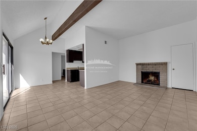 Unfurnished living room featuring light tile patterned flooring, a fireplace, a chandelier, a textured ceiling, and beam ceiling