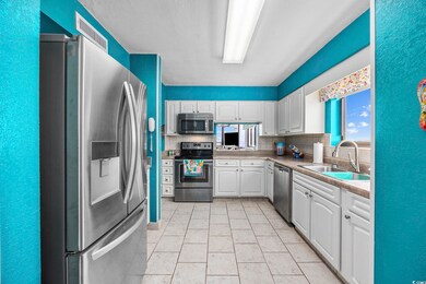 Kitchen with white cabinetry, decorative backsplas