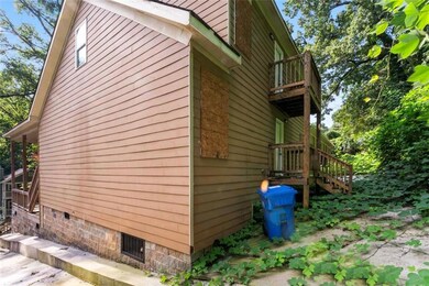 View of property exterior with stairway and a balcony