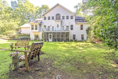 Rear view of property with a sunroom and a yard