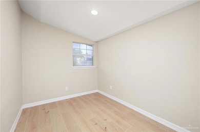 Unfurnished room with light wood-style flooring, baseboards, lofted ceiling, and recessed lighting
