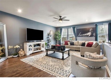 Living room featuring ceiling fan, a wealth of natural light, and dark hardwood / wood-style floors
