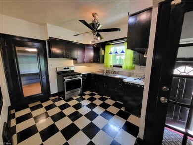 Kitchen featuring tile floors, dark brown cabinetr