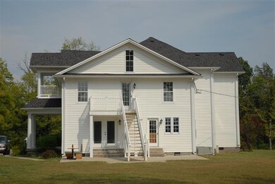 View of the back of the house with outside stairway  leading to your private backyard with patio.