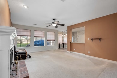 Kitchen partially opens to the window flanked livi