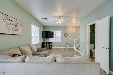Living area with a ceiling fan, wood finished floo