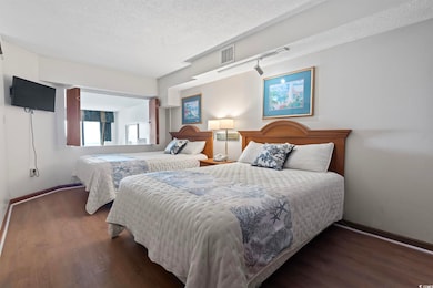Bedroom with dark hardwood / wood-style floors and