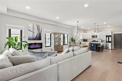 Living area with recessed lighting, plenty of natural light, a chandelier, and light wood-style floors