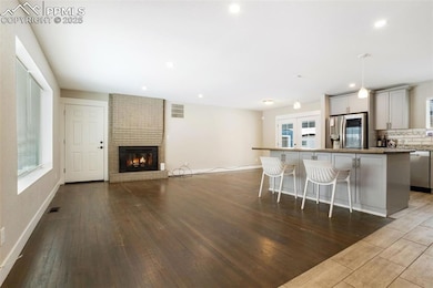 Kitchen featuring a breakfast bar area, hanging light fixtures, light hardwood / wood-style flooring, appliances with stainless steel finishes, and a kitchen island
