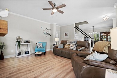 Living room with ceiling fan with notable chandeli