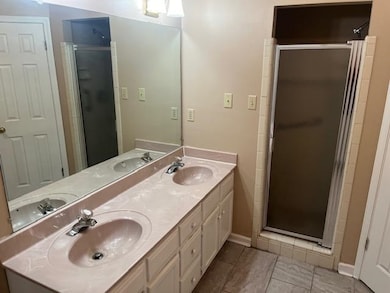 Bathroom with a shower with door, vanity, and tile