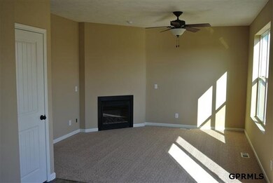 this family room featurs a fireplace, ceiling fan and overlooks the amazing back yard!