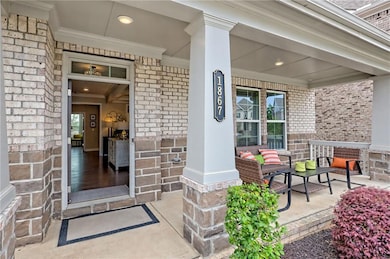 Entrance to property with a porch and brick siding